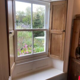 Bespoke Accoya timber box sash window with brass hardware and traditional sash horns installed at The Nest in Westbury Sub Mendip near Wells Somerset