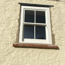 Bespoke Accoya timber box sash window with brass hardware and traditional sash horns installed at The Nest in Westbury Sub Mendip near Wells Somerset