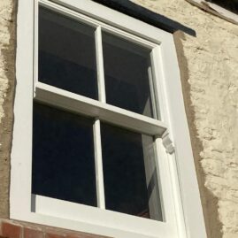 Bespoke Accoya timber box sash window with brass hardware and traditional sash horns installed at The Nest in Westbury Sub Mendip near Wells Somerset