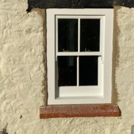 Bespoke Accoya timber box sash window with brass hardware and traditional sash horns installed at The Nest in Westbury Sub Mendip near Wells Somerset