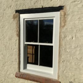 Bespoke Accoya timber box sash window with brass hardware and traditional sash horns installed at The Nest in Westbury Sub Mendip near Wells Somerset